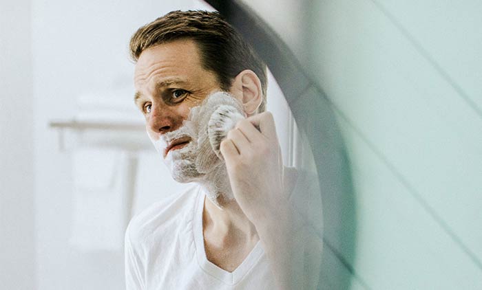 Man shaving with moisturizing shave cream to prevent folliculitis barbae